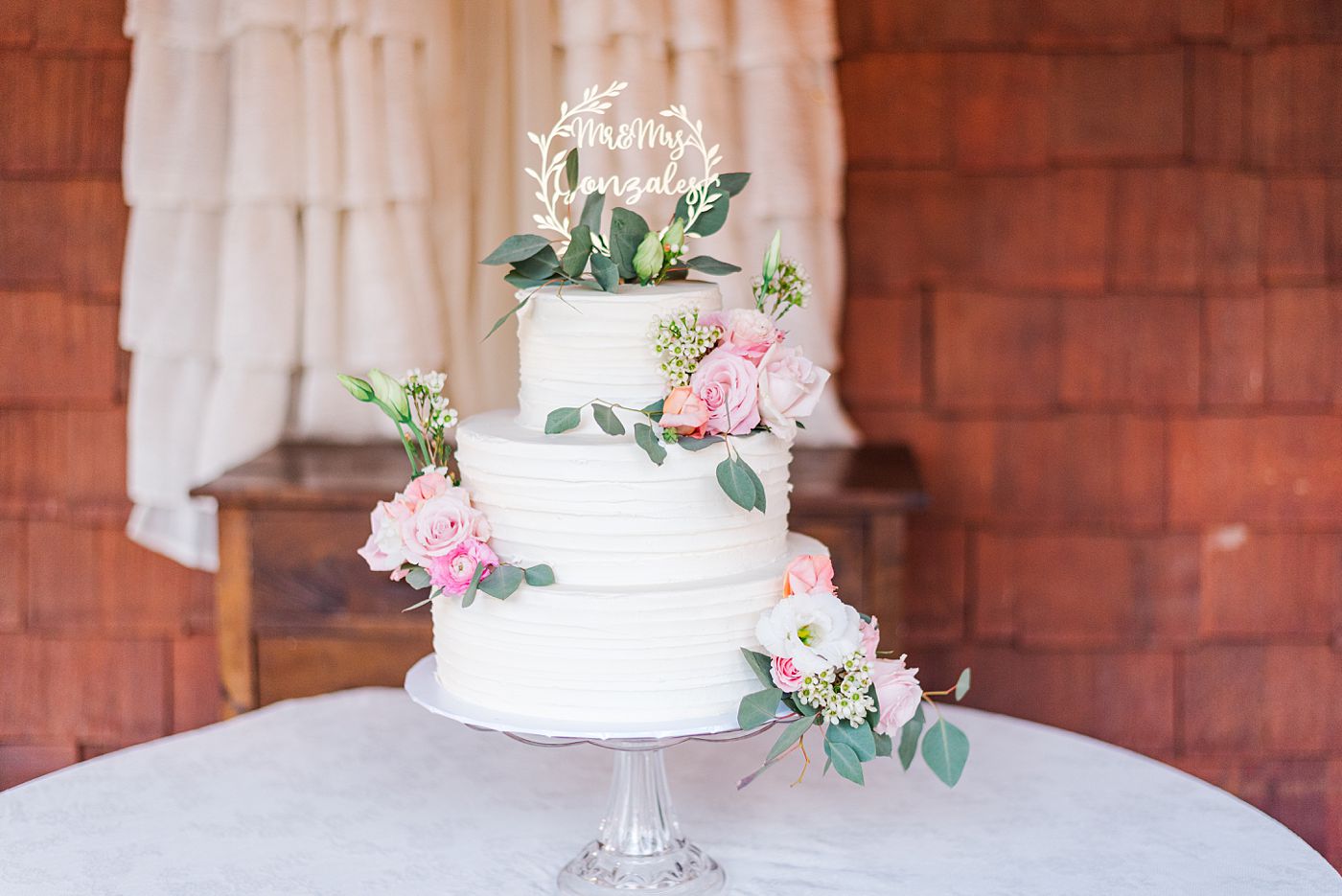a white wedding cake with pink roses 