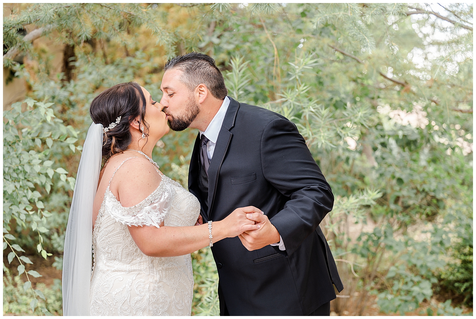 man in suit and woman in wedding gown kissing